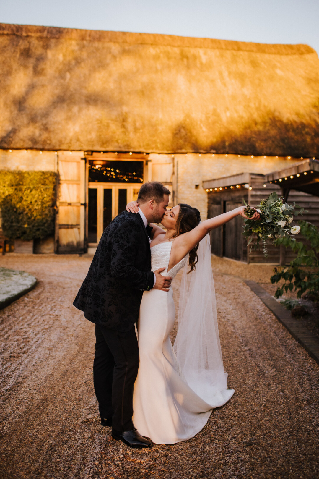 Newlyweds at the front of the barn at golden hour